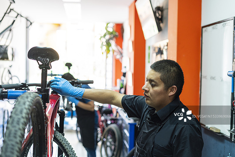 拉丁男人自行车技师在他的车间里图片素材