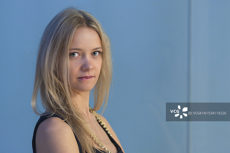 蓝色背景下的年轻女子肖像图片素材