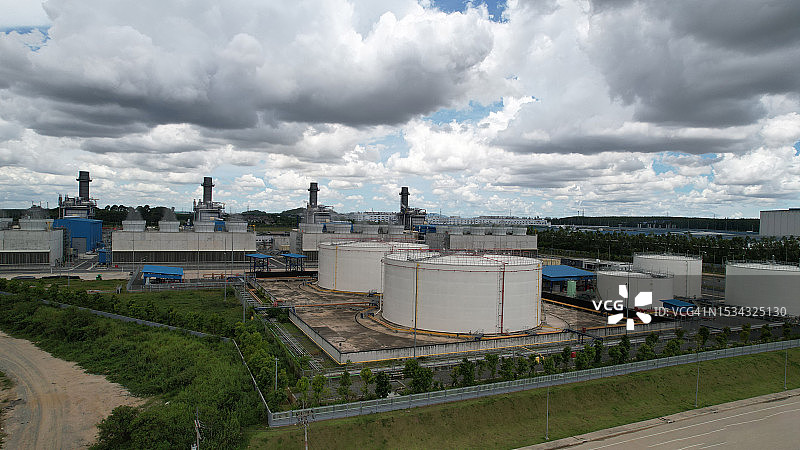 以发电厂为背景的油气储罐鸟瞰，商业电力和能源化工桶图片素材
