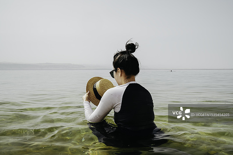 在约旦死海漂浮游泳的亚洲女性图片素材
