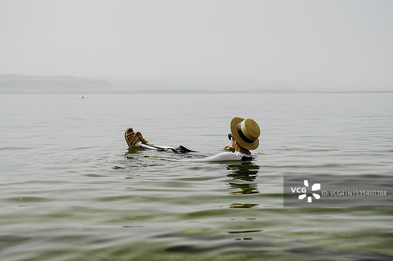 在约旦死海漂浮游泳的亚洲女性图片素材