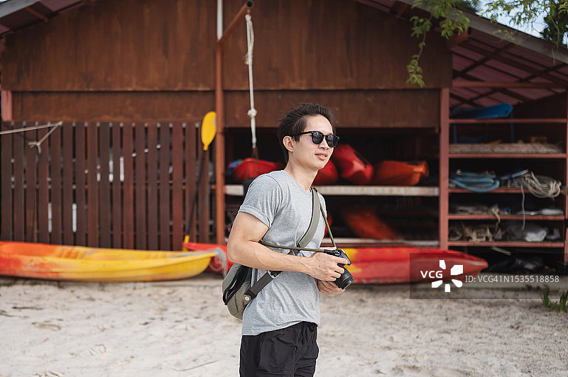 在泰国普吉岛甲米府放松，寻找社交媒体内容的亚洲网红，手持单反相机图片素材