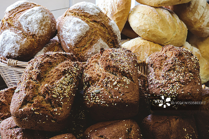 篮子里的各种面包，前景是棕色面包特写图片素材