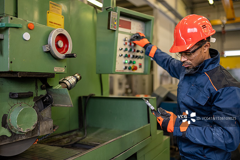 工业工人准备金属加工机器以进行工作图片素材