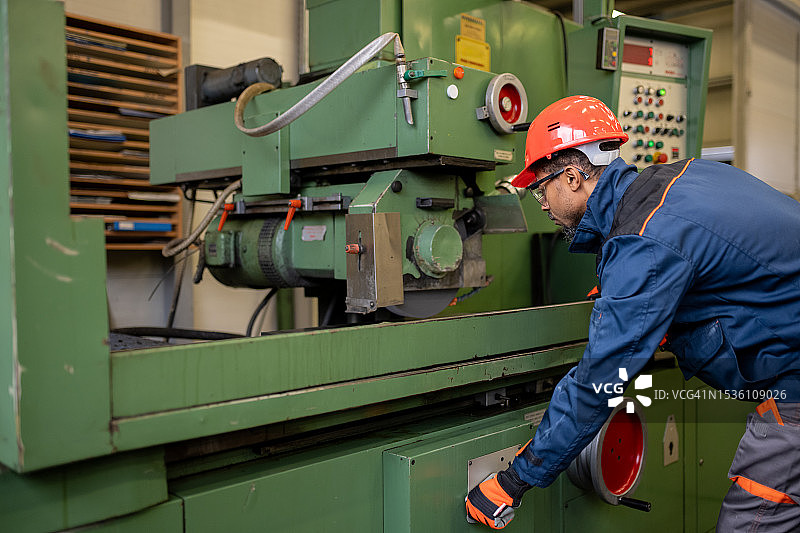 准备金属加工机器的深色皮肤产业工人图片素材