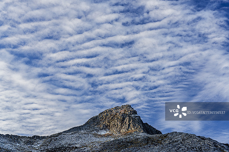 多云天空下的岩石山峰图片素材