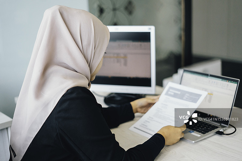 商务穆斯林女性阅读纸质简历以招聘合适人选图片素材