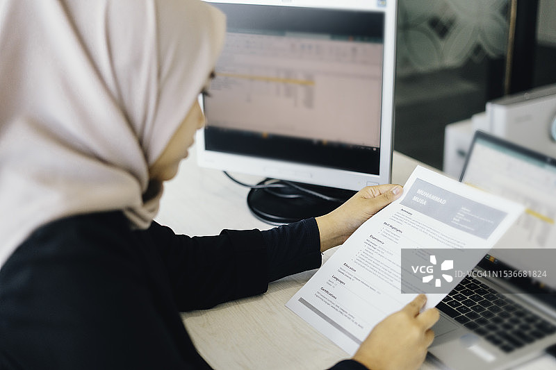 商务穆斯林女性阅读纸质简历以招聘合适人选图片素材