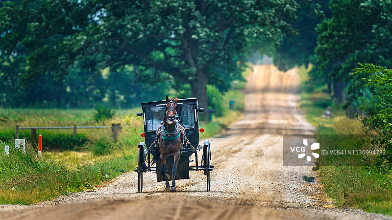 阿米什人的马车在乡村道路上图片素材
