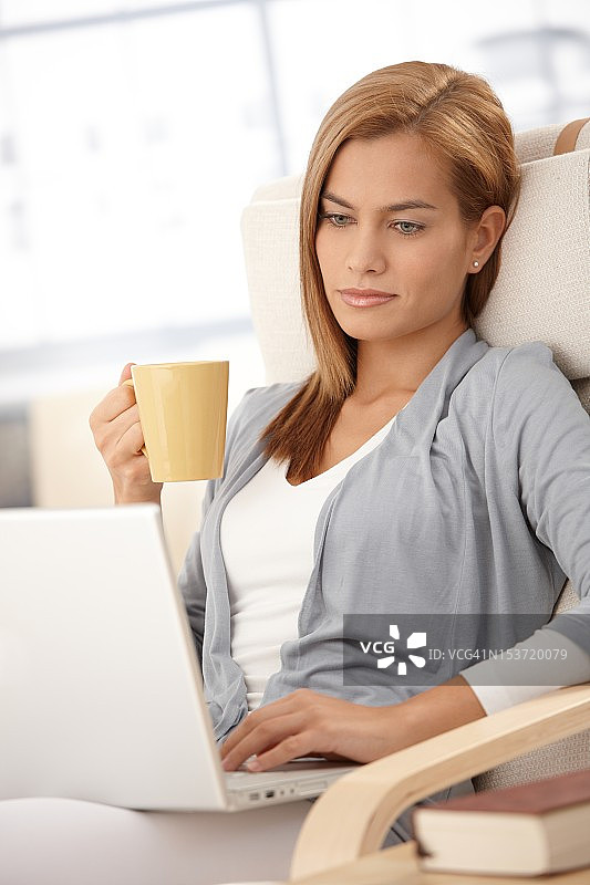 年轻女子在家里使用笔记本电脑图片素材