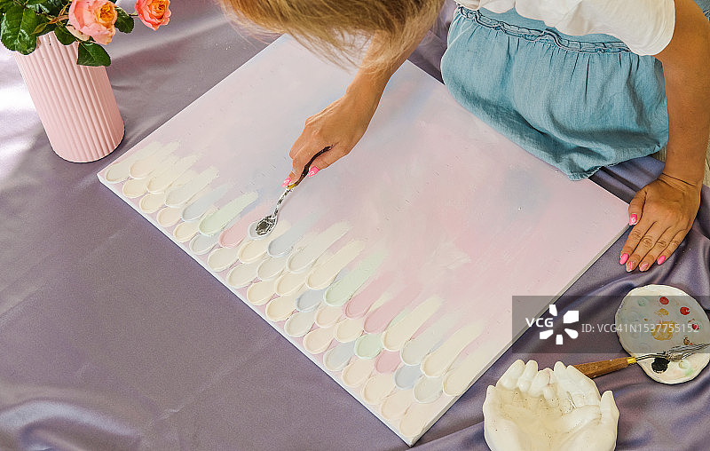 在家庭工作室里在彩色画布上绘画的女艺术家图片素材