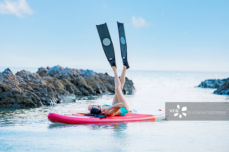 在泰国夏季假期的海上桨板上的亚洲运动女性图片素材