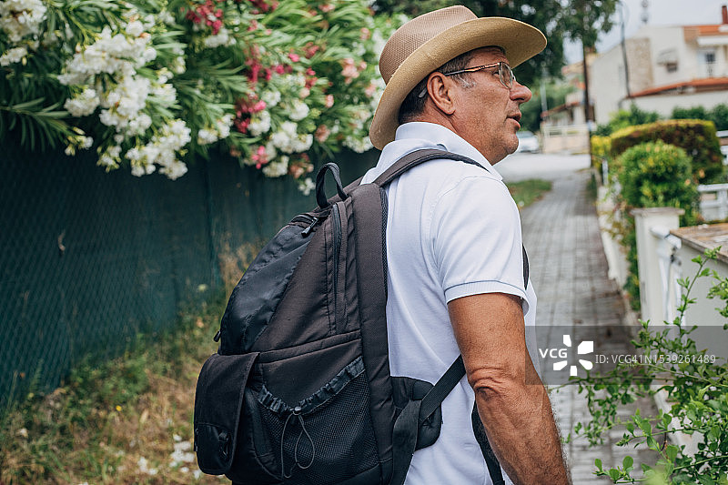 一位年长的游客正在游览这座城市的新目的地图片素材