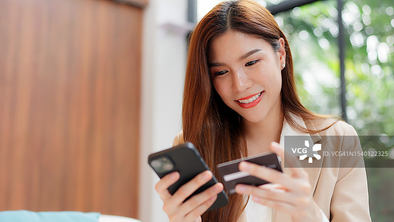 用信用卡和智能手机拥抱数字商务。 女商人利用智能手机的潜力，在网上购物时进行信用卡交易，开启无限可能的世界图片素材