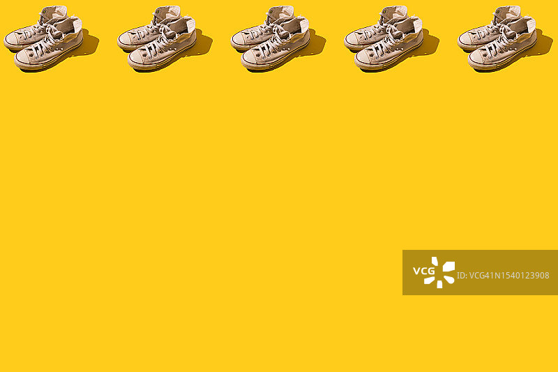 复古风格：黄色背景上的旧白色篮球鞋图案图片素材