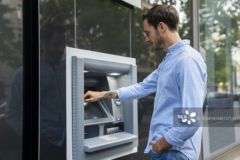 年轻男子从ATM取款图片素材