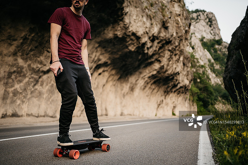 男子在日落时分尝试他的电动山地滑板图片素材