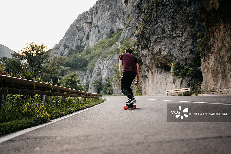 男子在日落时分尝试他的电动山地滑板图片素材