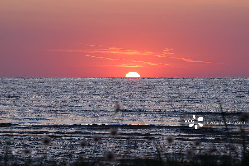 拉脱维亚橙色天空下的壮丽海景图片素材