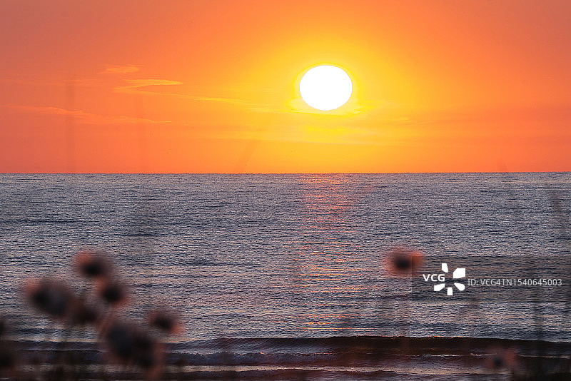 拉脱维亚橙色天空下的壮丽海景图片素材