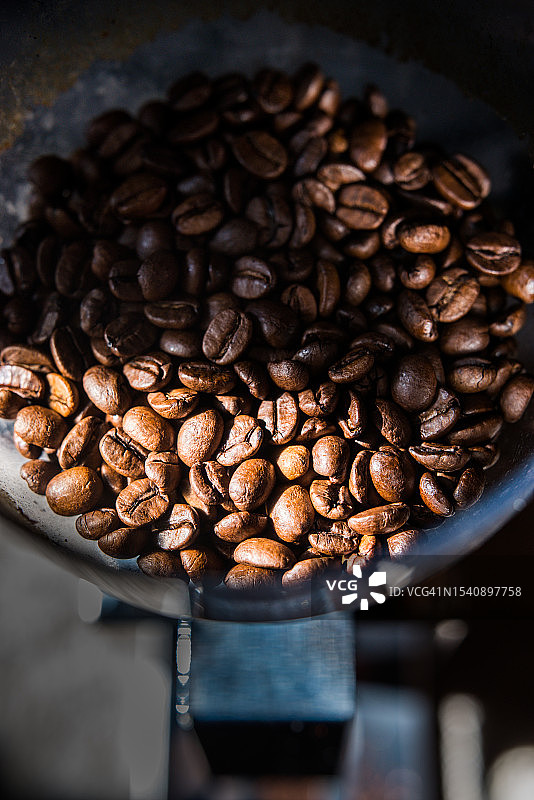 在家用咖啡研磨机中新鲜烘焙的咖啡豆图片素材
