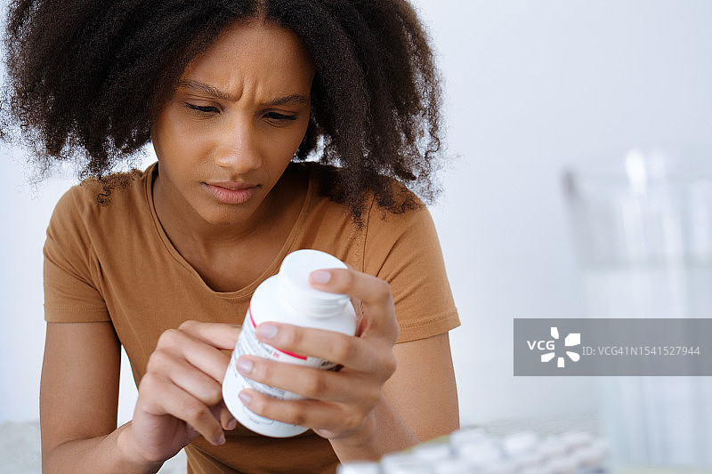 年轻女子在家中服用药丸图片素材