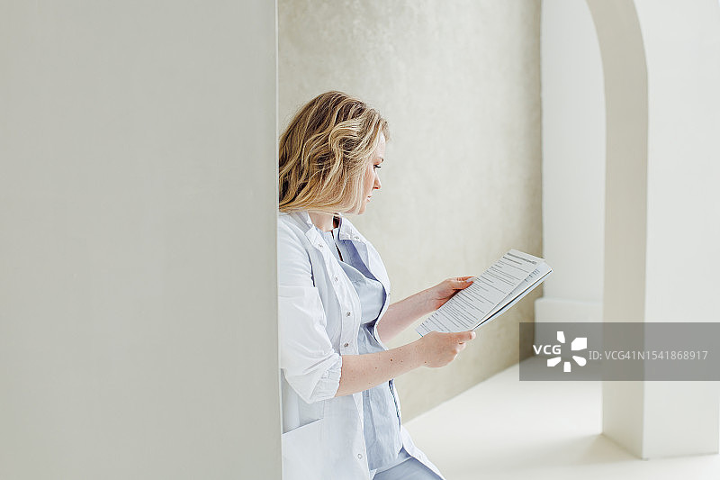 有爱心的女医务人员在宽敞的休息区休息时阅读实验室报告图片素材