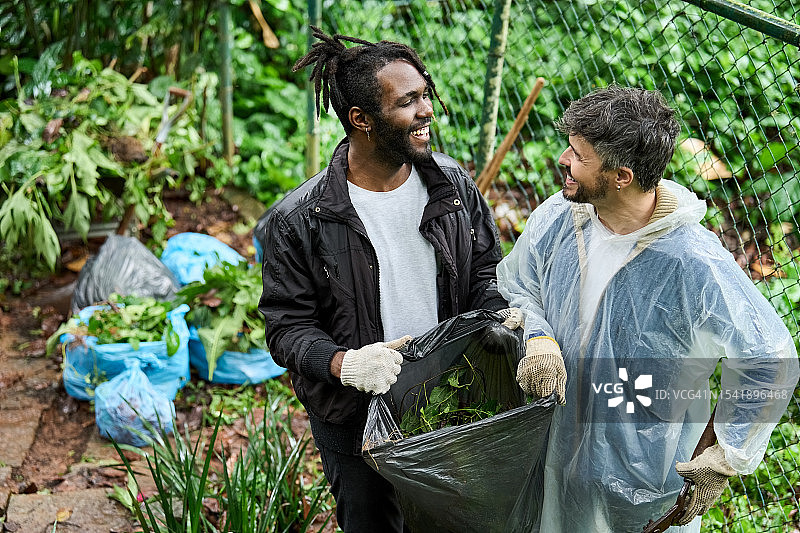 社区清洁志愿者雨中清理花园垃圾图片素材