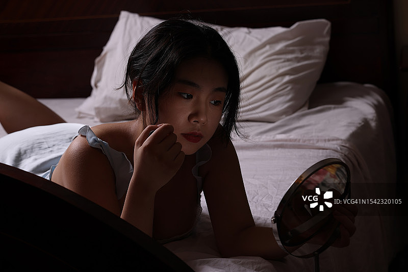 在床上化妆的中国女学生图片素材