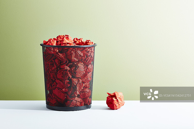 装满红色纸团的办公室废纸篓图片素材