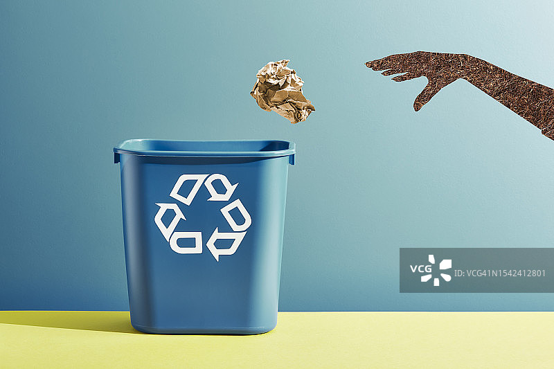 手将揉皱的棕色纸扔进回收箱图片素材