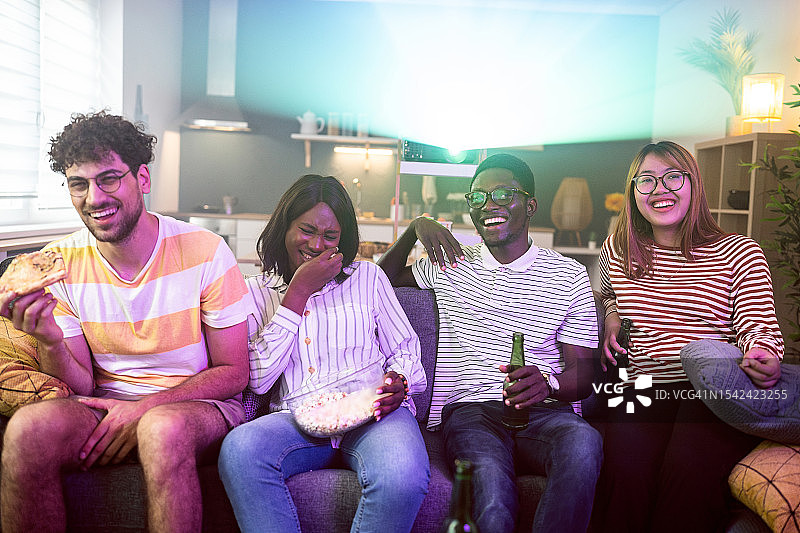 多种族朋友在家用投影仪看电影图片素材