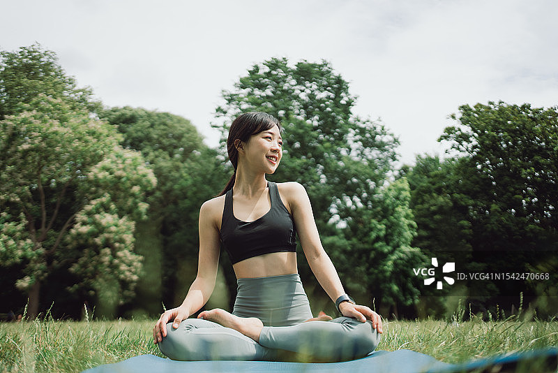 在公园里练习瑜伽的亚洲女性图片素材