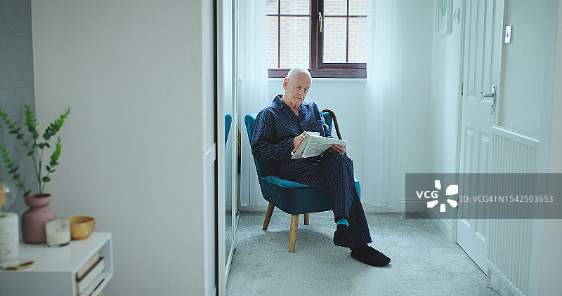 清晨，放松身心，老年男人在家中阅读报纸获取信息，缓解压力图片素材