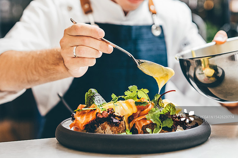 厨师准备美食特写：厨师在上菜前装饰盘子图片素材