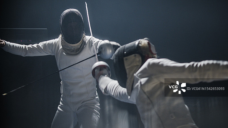 两位专业击剑手激烈对战，进攻并多次击中图片素材