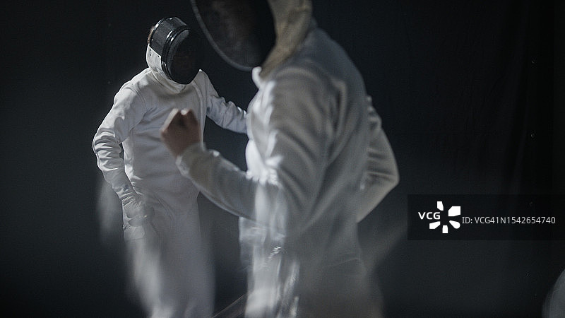 两位专业击剑手持花剑对战，击中后欢呼图片素材