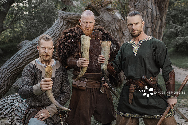 三个维京战士在秋天的森林里畅饮图片素材