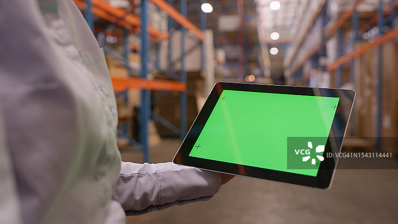 仓库中平板电脑绿屏样机，用于物流广告或监控图片素材