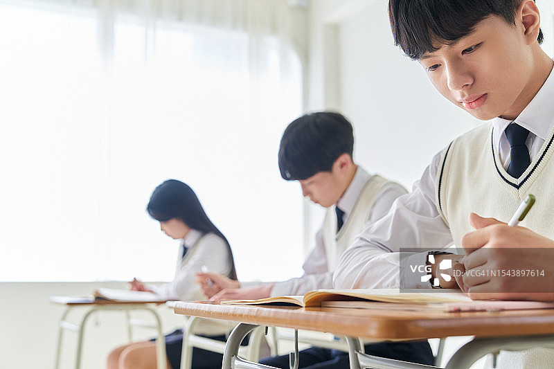 坐在书桌前学习的学生图片素材