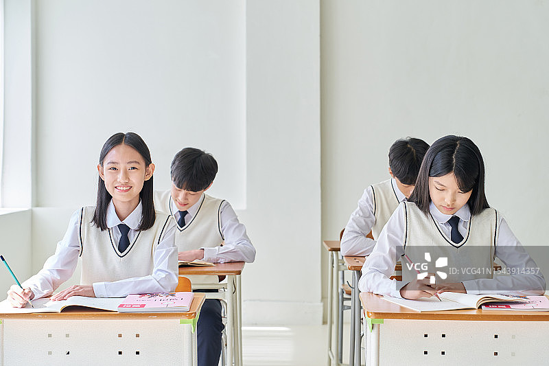 坐在书桌前学习的学生图片素材