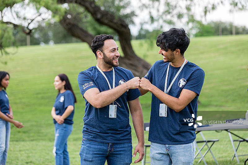年轻男人碰拳准备打扫公园图片素材