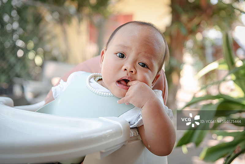 进食中玩耍婴儿的特写肖像图片素材