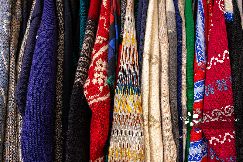 古董跳蚤市场上装满复古毛衣的衣架图片素材