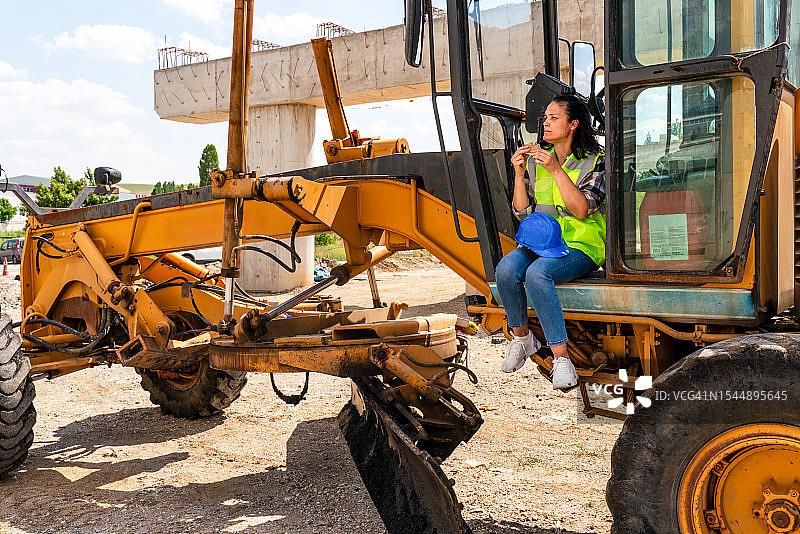 休息时吃三明治的女建筑工人图片素材
