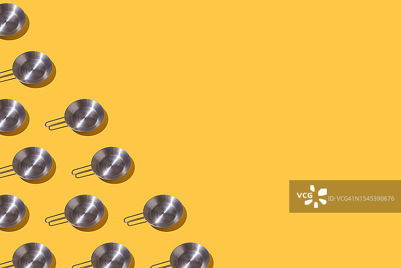 黄色背景上的钢锅图案。烹饪、煎炸、烧烤、厨师、食物概念。图片素材