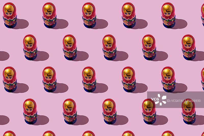 粉色背景上的金色、红色和蓝色俄罗斯套娃图案图片素材
