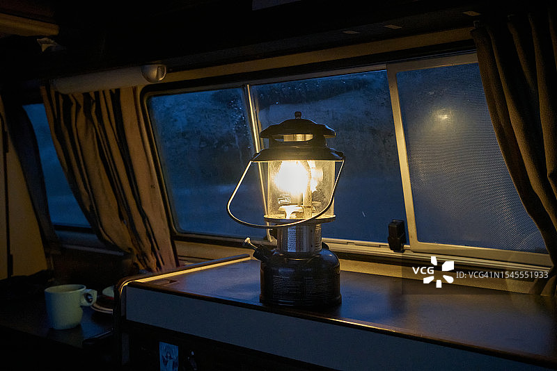 温哥华岛露营之夜：石蜡灯照亮露营车内部图片素材