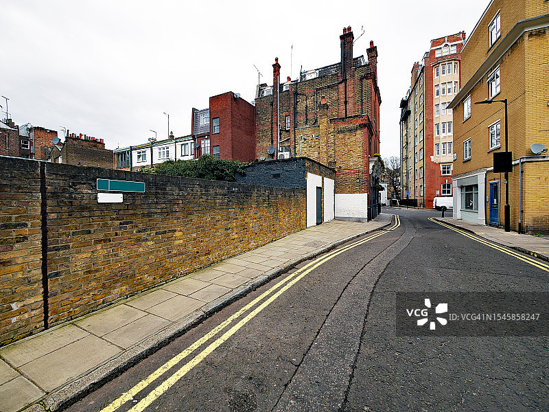 英国伦敦，空旷的街道两旁是饱经风霜的砖墙和古老的住宅楼图片素材