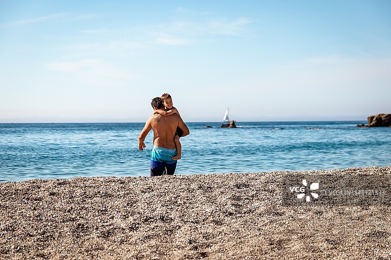 爸爸和儿子在海滩玩耍图片素材